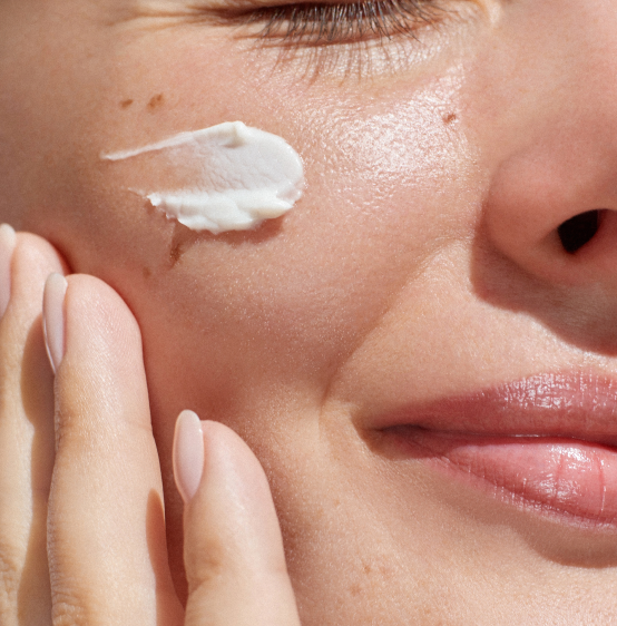 Close-up of woman's face with skin cream, representing gut health and skin wellness.